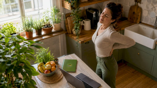 Woman adjusting back in home office setup