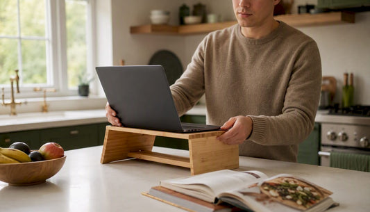 Person adjusting laptop height at home desk